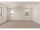 Spacious bedroom with carpeted floors and two windows, bringing in ample natural light at 11623 W Green Dr, Youngtown, AZ 85363