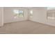 Large, carpeted bedroom with multiple windows, offering plenty of natural light and views at 11623 W Green Dr, Youngtown, AZ 85363