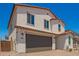 Exterior front view of a two-story home with a clay tile roof and a spacious two-car garage at 11623 W Green Dr, Youngtown, AZ 85363