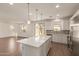 Open-concept kitchen boasts a spacious island, stainless steel appliances, and seamless flow into the adjacent living area at 11623 W Green Dr, Youngtown, AZ 85363