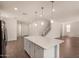 Bright kitchen with an island perfect for entertaining, flowing into an open floor plan with staircase and wood tile floors at 11623 W Green Dr, Youngtown, AZ 85363