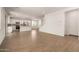 Spacious living area with wood-look tile flooring and a modern kitchen, creating an inviting open-concept layout at 11623 W Green Dr, Youngtown, AZ 85363