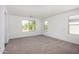 Spacious bedroom with plush carpeting and multiple windows that provide natural light and outdoor views at 11627 W Green Dr, Youngtown, AZ 85363