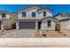 Inviting two-story home featuring desert landscaping, a paver driveway, and a two-car garage at 11627 W Green Dr, Youngtown, AZ 85363