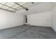 Spacious two-car garage with white walls, concrete floor, and two convenient entry doors at 11627 W Green Dr, Youngtown, AZ 85363
