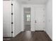 Hallway with neutral tile flooring, white doors, and a view to a bright bedroom space at 11627 W Green Dr, Youngtown, AZ 85363