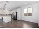 Modern kitchen with white cabinets, stainless steel appliances, and a large island, flowing into an open space at 11627 W Green Dr, Youngtown, AZ 85363