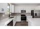 Modern kitchen features white cabinetry, stainless steel appliances, and quartz countertops at 11627 W Green Dr, Youngtown, AZ 85363