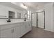 Modern bathroom with double vanity, black fixtures, and glass-enclosed shower at 11631 W Green Dr, Youngtown, AZ 85363