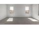 Bedroom with two windows, neutral carpet, and white trim, offering a bright, modern space at 11631 W Green Dr, Youngtown, AZ 85363
