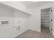 Well-lit laundry room with white shelving and tile floor, plus additional storage room at 11631 W Green Dr, Youngtown, AZ 85363