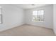 Comfortable bedroom featuring neutral carpet, bright white walls, and views of the neighborhood at 11635 W Beck Ave, Youngtown, AZ 85363