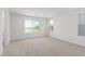 Spacious bedroom with neutral carpet, bright white walls, and large windows overlooking the neighborhood at 11635 W Beck Ave, Youngtown, AZ 85363