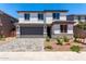 Attractive two-story home with modern design elements, desert landscaping, and a paved driveway at 11635 W Beck Ave, Youngtown, AZ 85363