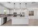 Bright kitchen features white cabinets, stainless steel appliances, and an island for added workspace at 11635 W Beck Ave, Youngtown, AZ 85363