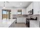 Kitchen boasting stainless steel appliances, white cabinets, and tile backsplash, providing a sleek and modern feel at 11635 W Beck Ave, Youngtown, AZ 85363