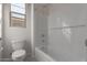Clean bathroom featuring a white tiled shower-tub combo and toilet at 12022 W Marguerite Ave, Avondale, AZ 85323