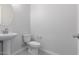 Modern bathroom with a sleek pedestal sink and toilet, featuring neutral tones and fixtures at 12022 W Marguerite Ave, Avondale, AZ 85323