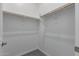 Empty walk-in closet with wood rods for hanging clothes at 12022 W Marguerite Ave, Avondale, AZ 85323