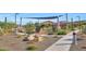 Community amenity area featuring playground equipment and a shaded bench with lush green trees at 13448 W Auburn Dr, Peoria, AZ 85383