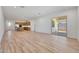 Bright and airy living room featuring wood-style tile floors and easy access to the kitchen and back yard at 13448 W Auburn Dr, Peoria, AZ 85383