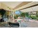 A shaded patio space is perfect for relaxing outdoors with comfortable seating arrangements and lush landscaping at 14111 W Cavalcade Dr, Sun City West, AZ 85375
