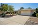 Spacious driveway leading to a two-car garage, surrounded by low-maintenance desert landscaping at 14111 W Cavalcade Dr, Sun City West, AZ 85375