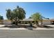Well-maintained home exterior with desert landscaping, mature trees, and attached garages at 14111 W Cavalcade Dr, Sun City West, AZ 85375