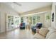Comfortable living room with tile flooring, large windows with plantation shutters, and access to the patio at 14111 W Cavalcade Dr, Sun City West, AZ 85375