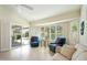 Living room with tile flooring, large windows with plantation shutters, and access to outdoor living at 14111 W Cavalcade Dr, Sun City West, AZ 85375
