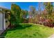 Lush backyard featuring vibrant green lawn, shade trees and blooming foliage with brick planter at 1434 W Meseto Ave, Mesa, AZ 85202