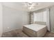 Neutral bedroom with a queen sized bed, lighted ceiling fan, and natural lighting at 1434 W Meseto Ave, Mesa, AZ 85202