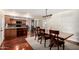 Open-concept dining area with hardwood floors adjacent to the kitchen and light fixture at 1434 W Meseto Ave, Mesa, AZ 85202
