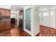 Hallway features hardwood floors, a pantry, stainless refrigerator and white front door at 1434 W Meseto Ave, Mesa, AZ 85202