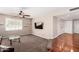 Inviting living room featuring a ceiling fan, floating shelves, and stairs to wood flooring at 1434 W Meseto Ave, Mesa, AZ 85202