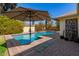 Beautiful pool with brick surround, umbrella and green plants adds to the charm at 1434 W Meseto Ave, Mesa, AZ 85202