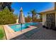 Beautiful pool with brick surround, umbrella and green plants adds to the charm at 1434 W Meseto Ave, Mesa, AZ 85202