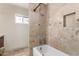 Bathroom with shower/tub combo, travertine tile surround, and a built in niche at 1434 W Meseto Ave, Mesa, AZ 85202