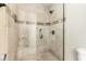 Elegant walk-in shower with glass doors, decorative tiles, and built-in bench at 1434 W Meseto Ave, Mesa, AZ 85202