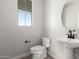 Modern half-bath features a pedestal sink, round mirror, and neutral color scheme at 15584 S 180Th Ln, Goodyear, AZ 85338