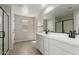 Bright bathroom with double sinks, white cabinets, a large mirror, and a modern shower at 15584 S 180Th Ln, Goodyear, AZ 85338