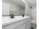 Bathroom featuring double sinks, modern black faucets, white cabinets, and a large mirror at 15584 S 180Th Ln, Goodyear, AZ 85338