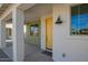 Inviting front porch with sturdy white columns, a bright yellow door, and a modern light fixture at 15584 S 180Th Ln, Goodyear, AZ 85338