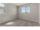 Bright bedroom with neutral walls and carpet, showcasing a large window for natural light at 15586 S 181St Dr, Goodyear, AZ 85338