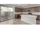Modern kitchen with quartz countertops, center island, stainless steel appliances, and backyard access at 15586 S 181St Dr, Goodyear, AZ 85338