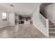 Bright, open-concept living space showcasing tile flooring, staircase, and flows into the modern kitchen at 15586 S 181St Dr, Goodyear, AZ 85338