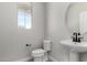 Stylish powder room featuring a pedestal sink, modern fixtures, and a bright window at 15586 S 181St Dr, Goodyear, AZ 85338