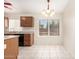 Eat-in kitchen featuring wood cabinetry, a large window, and tile flooring at 16802 N 20Th St, Phoenix, AZ 85022