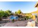 Large backyard featuring a pool with safety fence, patio and lush landscaping at 17466 N 64Th Ave, Glendale, AZ 85308