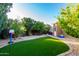 Well-maintained backyard featuring an artificial lawn, shed, and mature landscaping at 17466 N 64Th Ave, Glendale, AZ 85308